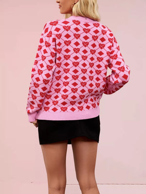Pink argyle knit sweater with red hearts and diamonds pattern, crew neck, long sleeves.