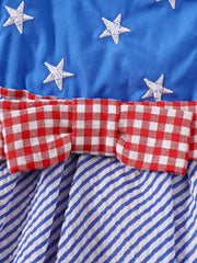 Patriotic baby dress with blue star top, red gingham bow, and blue striped skirt.