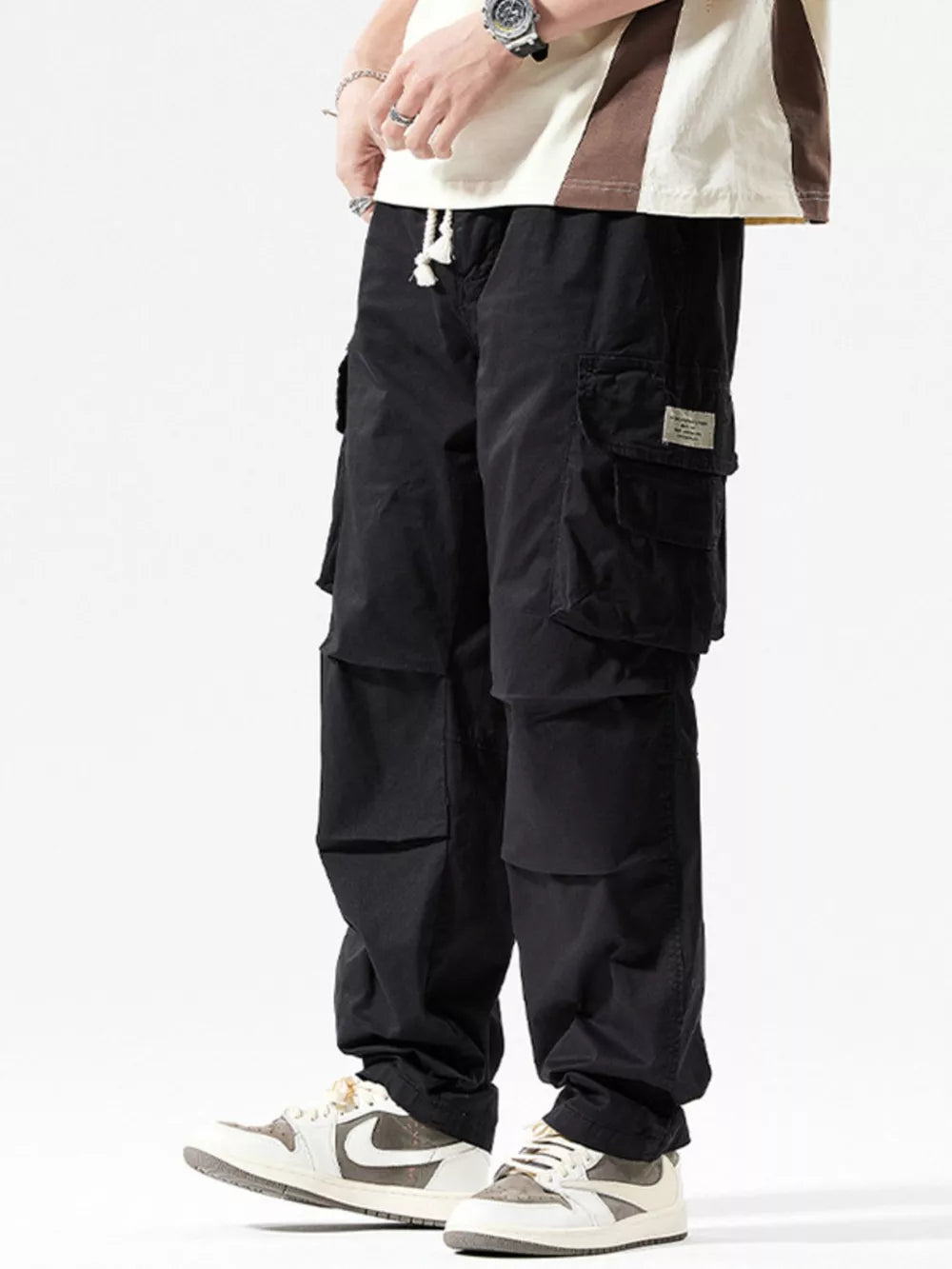 Men's black cargo pants with multiple pockets and a drawstring waist.
