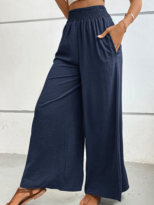 Dark blue textured maternity palazzo trousers with smocked waist and pockets.