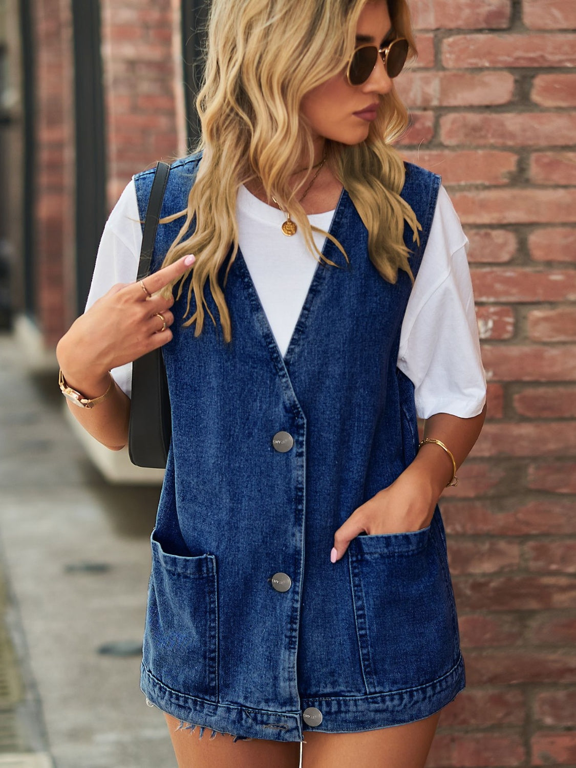 Medium wash denim oversized vest with patch pockets and button front.