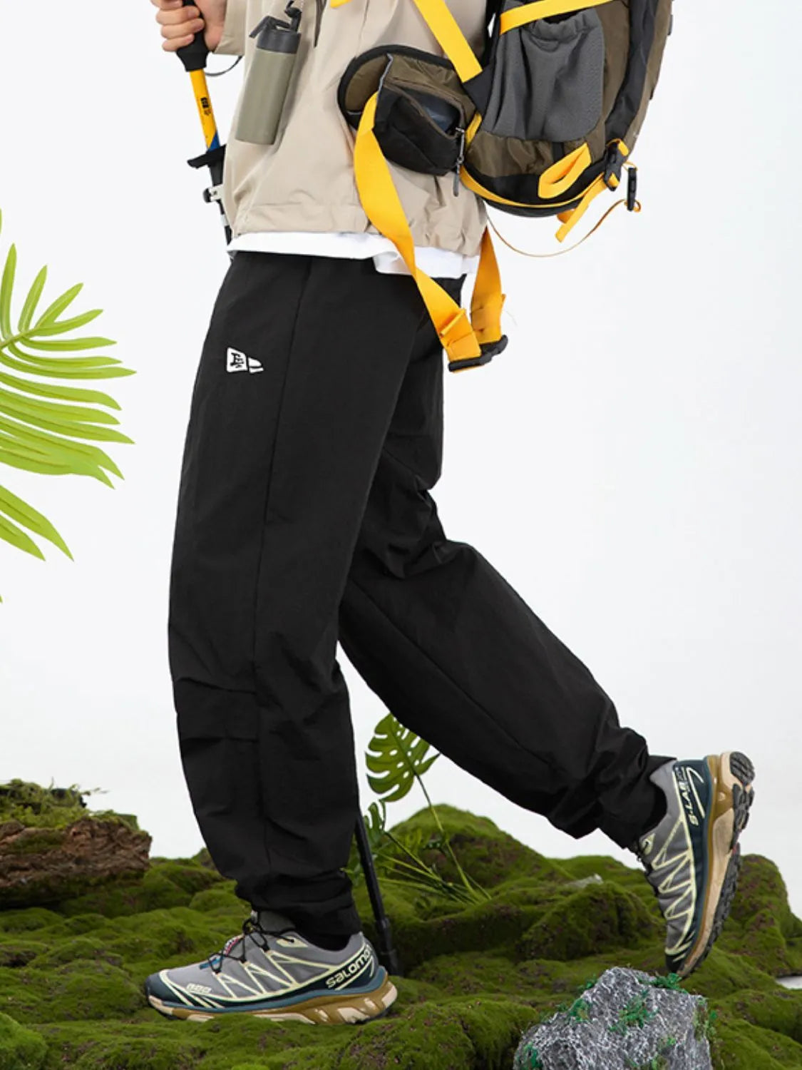 Black utility joggers with relaxed fit and logo detail, styled for adventure.