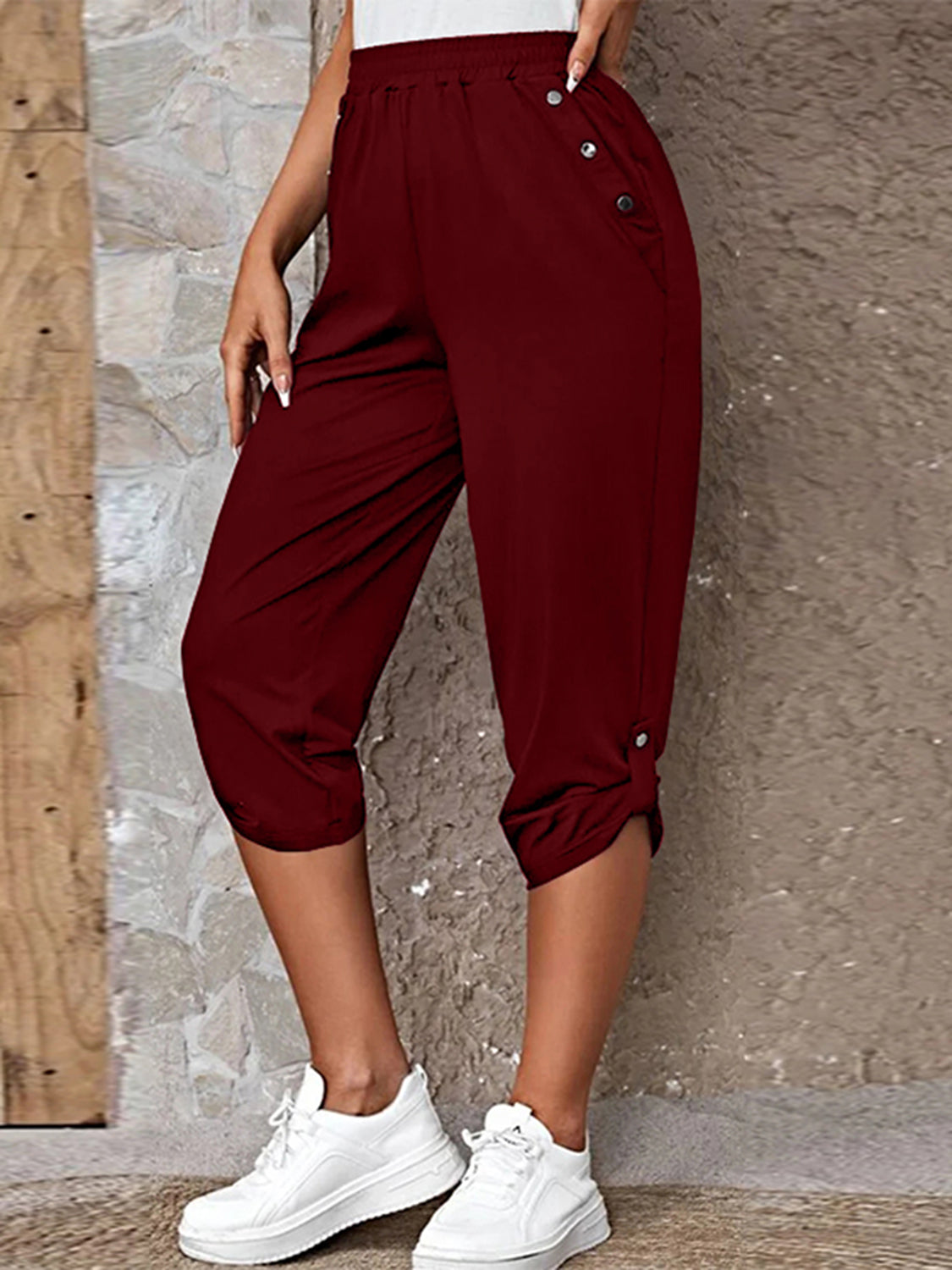 Burgundy culottes with button details and cuffed hems, styled with white sneakers.