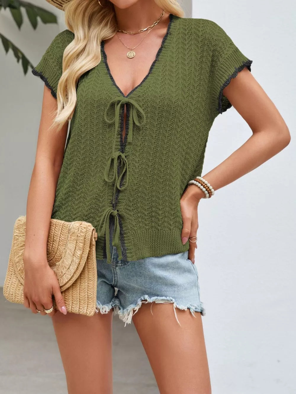 Green knit cardigan with short sleeves and tie-front detail, featuring contrast trim.