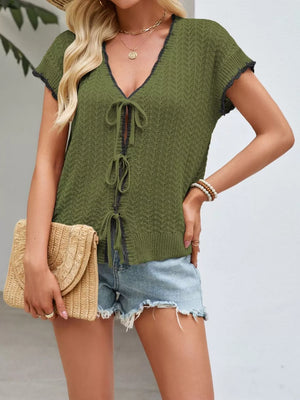 Green knit cardigan with short sleeves and tie-front detail, featuring contrast trim.