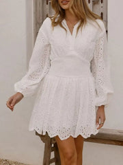 White eyelet mini dress with balloon sleeves and smocked waist.
