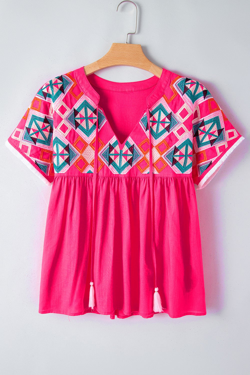 Strawberry embroidered yoke tie-neckline blouse with short sleeves and tassel details.