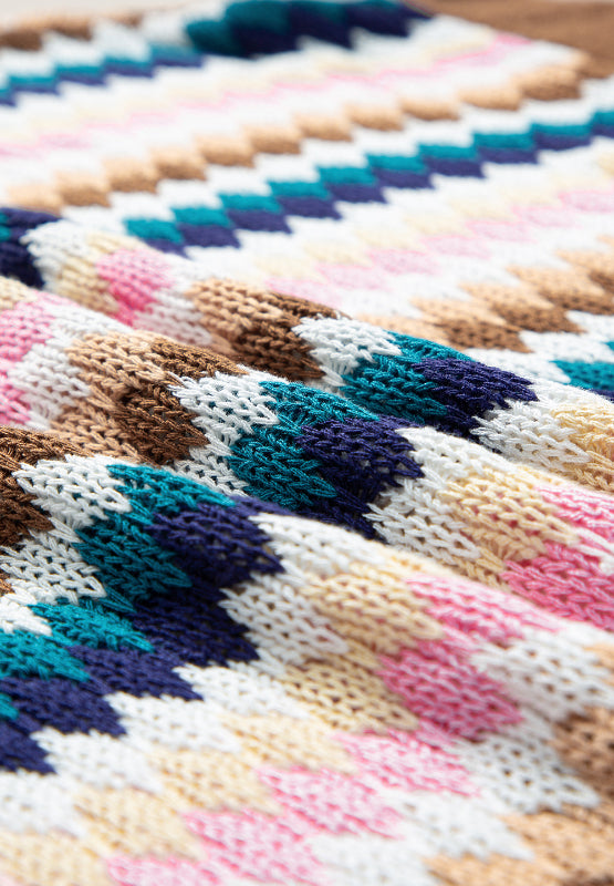 Textured knit sweater with a colorful chevron stripe pattern and contrast trim detail.