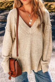 Beige open-knit slouchy v-neck sweater with textured detail and relaxed fit.