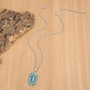 Southwestern teal turquoise cluster necklace with silver chain and oval pendant.