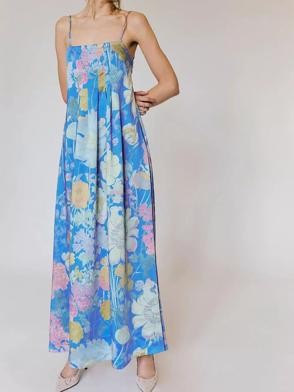 Maxi dress in sky blue with vibrant floral print, gathered bodice, and spaghetti straps.