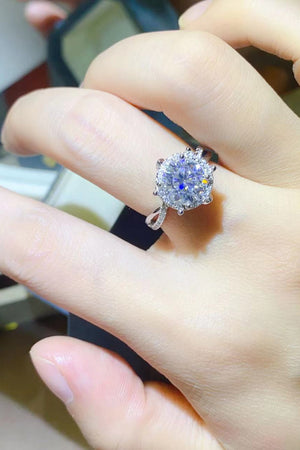 Silver moissanite halo engagement ring with a twisted band.