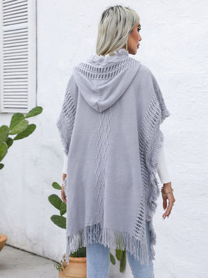 Gray knit poncho with fringe, crochet detail, and diamond pattern.