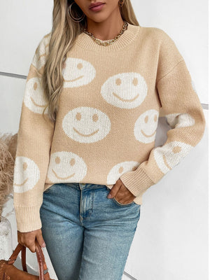 Tan intarsia knit sweater with allover white smiley faces, crew neck, long sleeves.