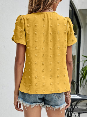 Textured puff sleeve mustard blouse with dot pattern and V-neck.