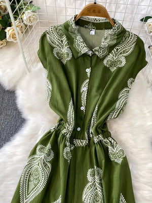 Green button-down romper with white paisley print, collared neckline and elastic waist.
