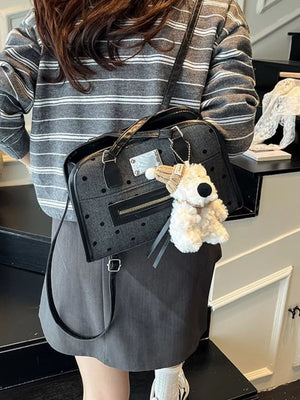 Sophisticated black polka dot shoulder bag with a fuzzy bear charm.