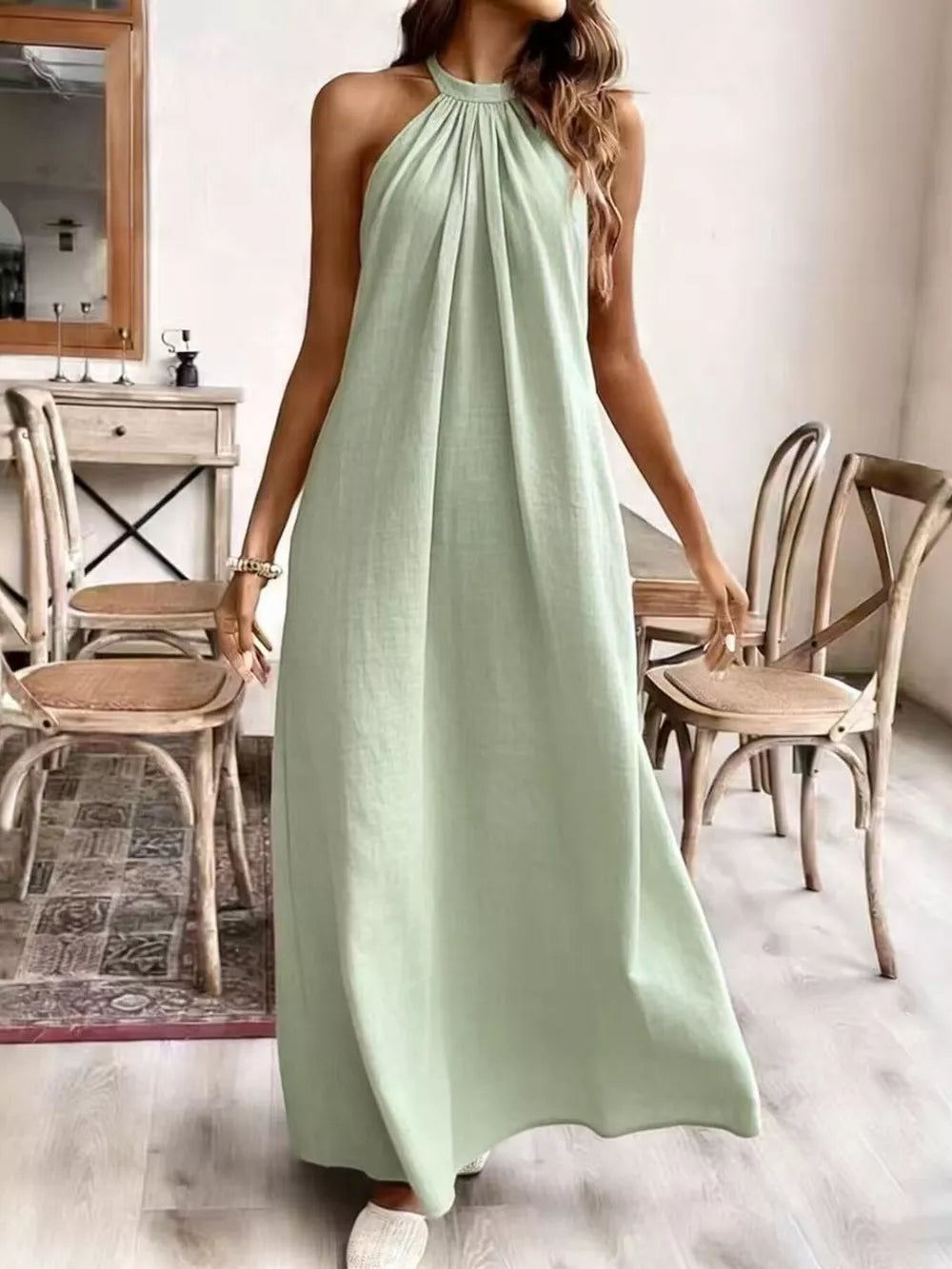 Light green ruched halter maxi gown with a flowing skirt.