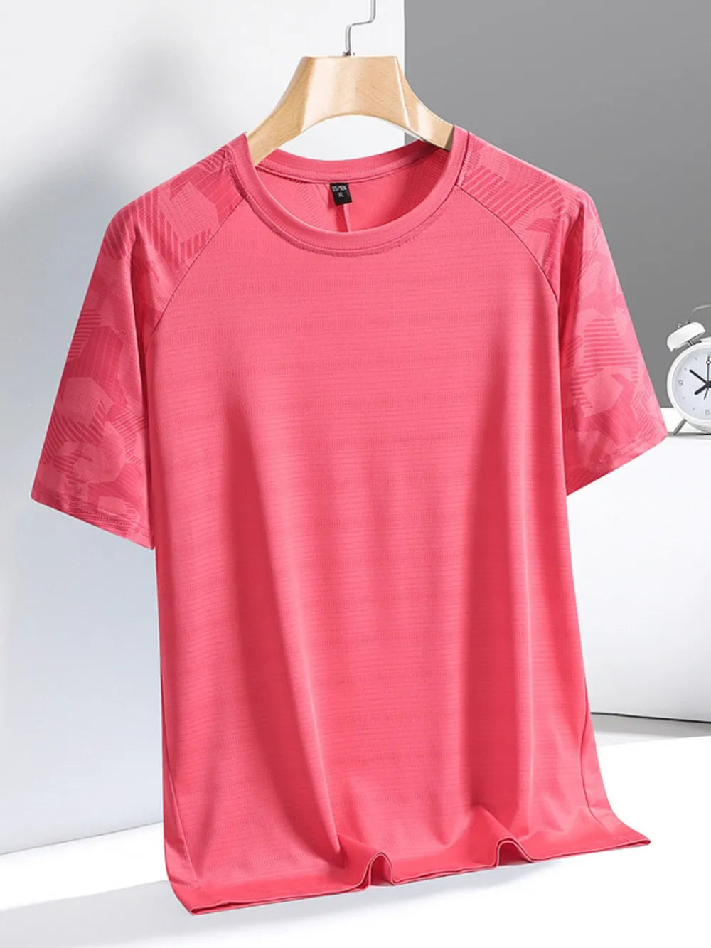 Men's pink quick-dry activewear tee with subtle textured sleeves and crew neck.