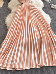 Elegant peach pleated maxi dress with cutout detail and a satin finish.