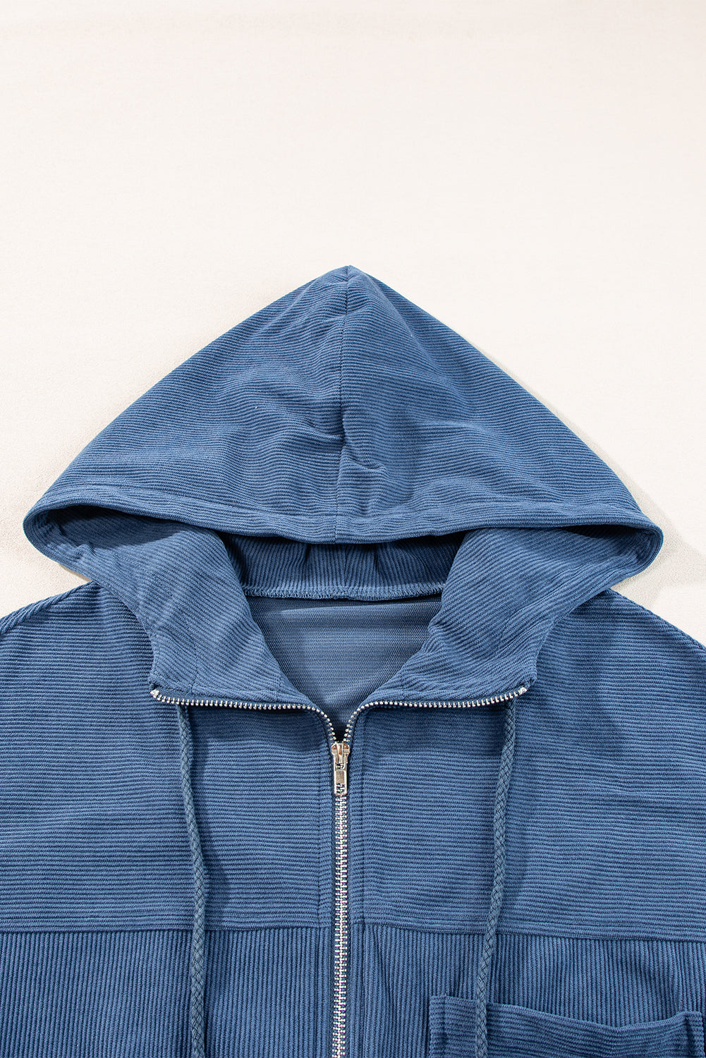 Dusty blue corduroy bomber hoodie with zipper and drawstring hood.