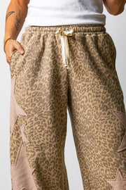 Brown leopard print relaxed fit pants with star patches and drawstring waist.