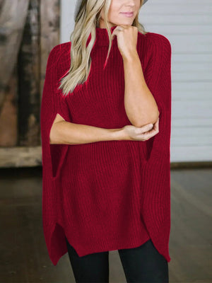 Red acrylic turtleneck sweater with cape sleeves and side slits.