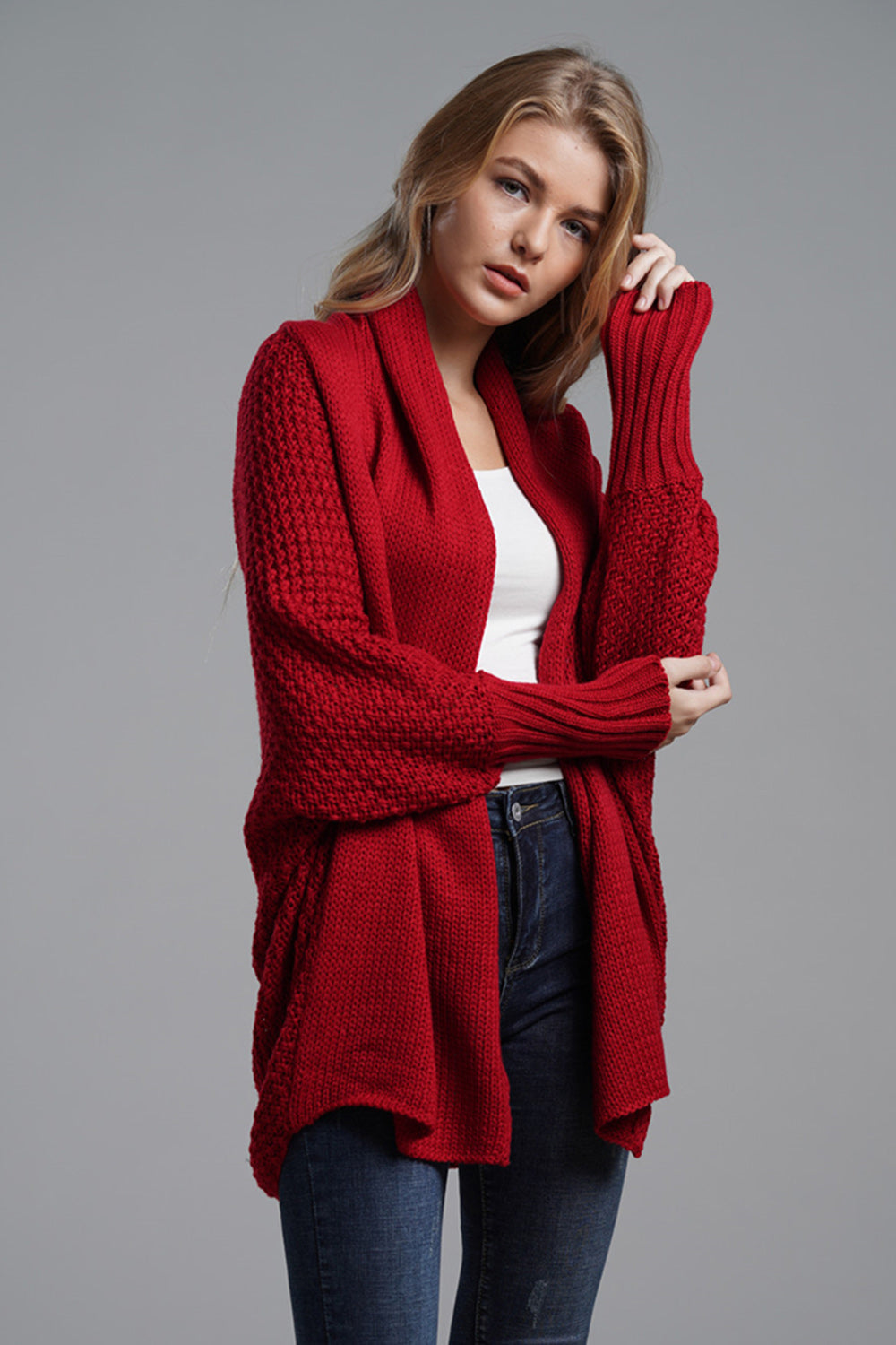 Red acrylic cocoon knit sleeve cardigan with textured sleeves and open front.
