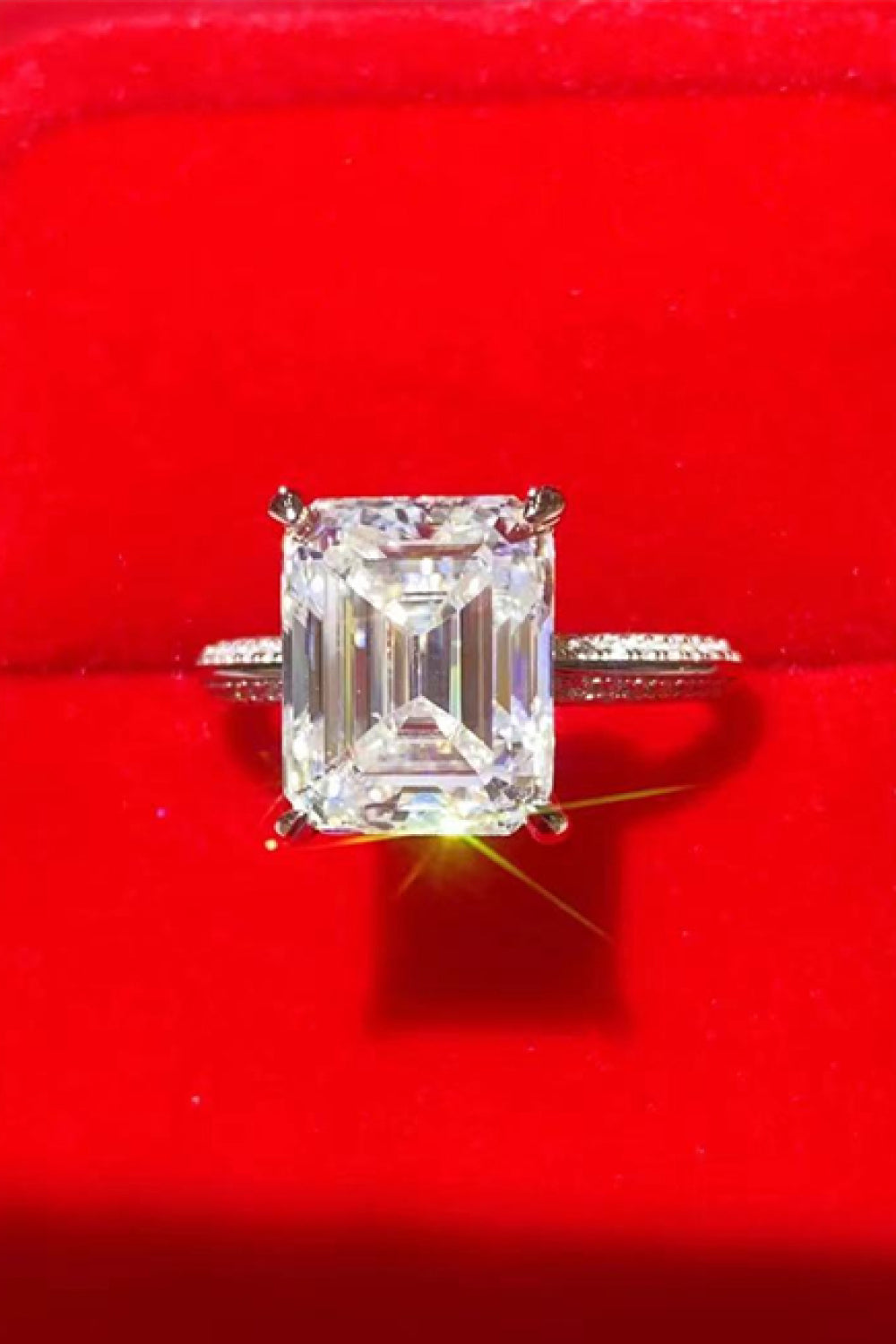 Platinum ring with emerald cut diamond and pavé band