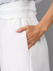 White wide-leg jumpsuit with pockets and a tie waist detail.