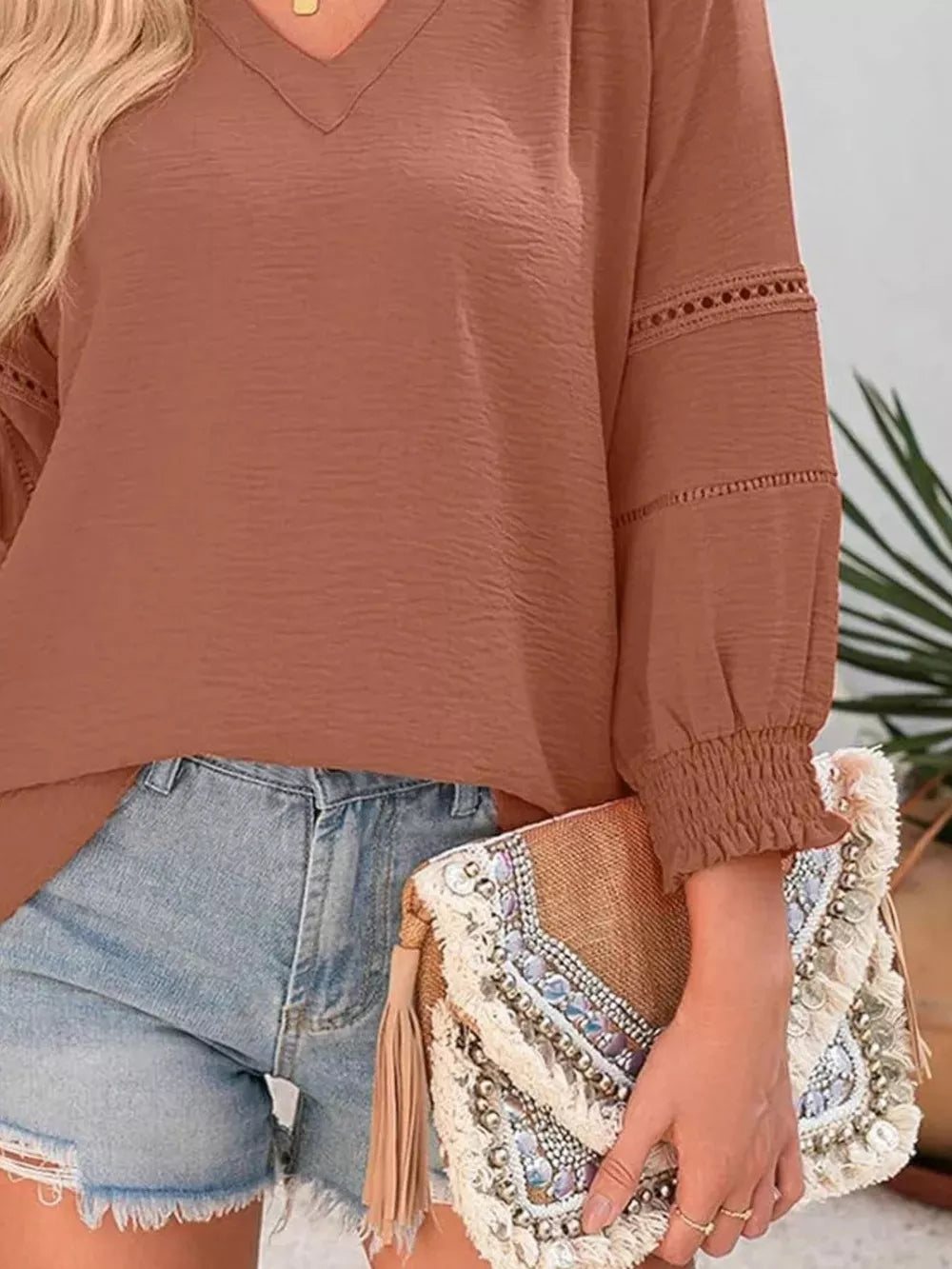 Caramel polyester blouse with smocked cuffs, V-neck, and eyelet detail on sleeves.