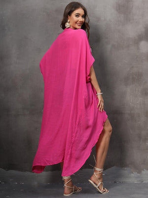 Hot pink asymmetrical flowing cover-up with a draped silhouette and high-low hem.