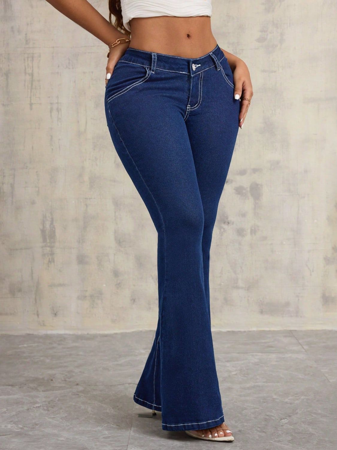 Dark wash denim flare jeans with contrast stitching and a high waist.