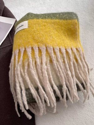 Plush multi-patterned scarf with yellow, green, and cream stripes and cream fringe.