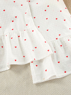 White cotton pajama set with red heart print and ruffled hem detail.