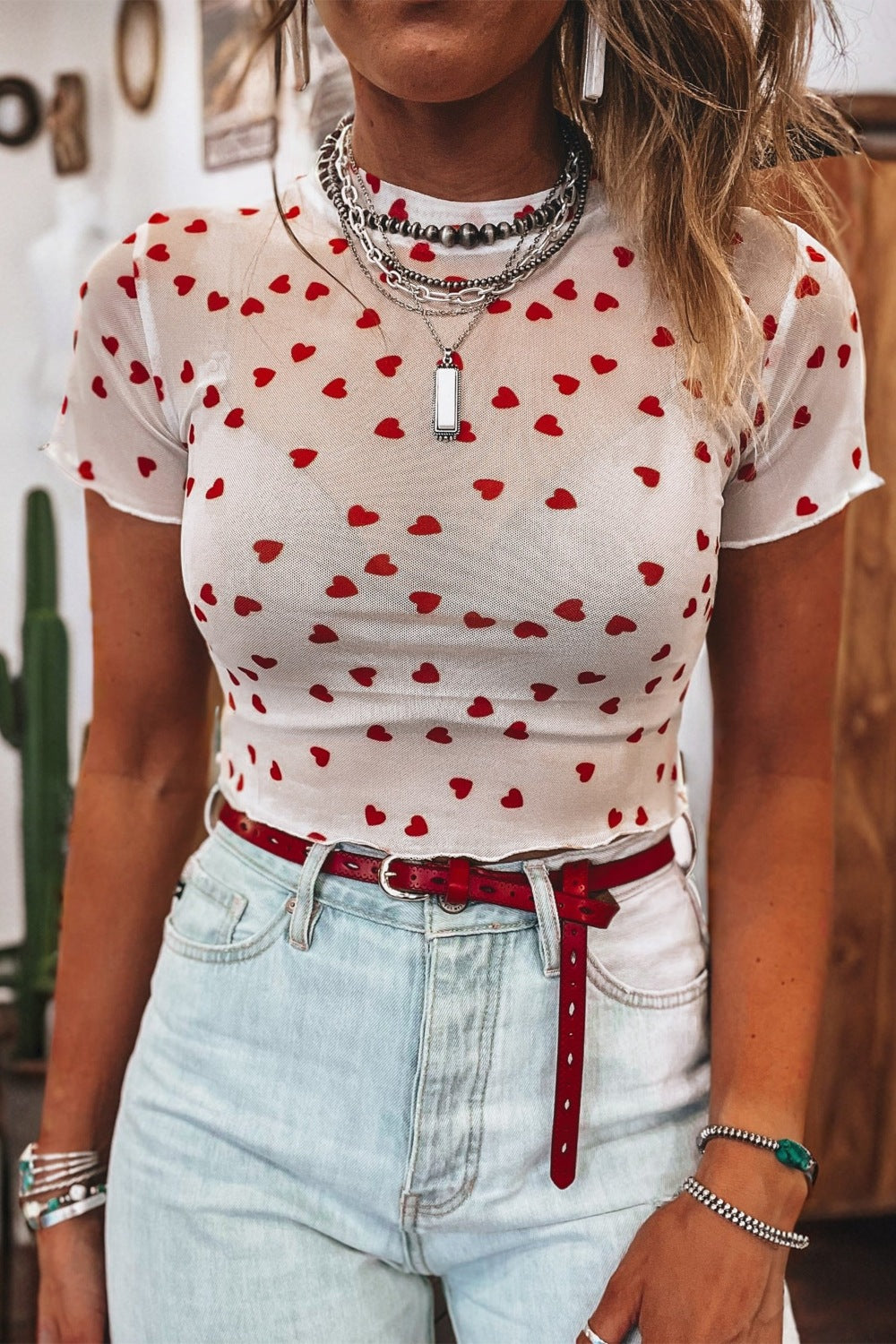 White sheer mesh t-shirt with red hearts, short sleeves, and lettuce hem.