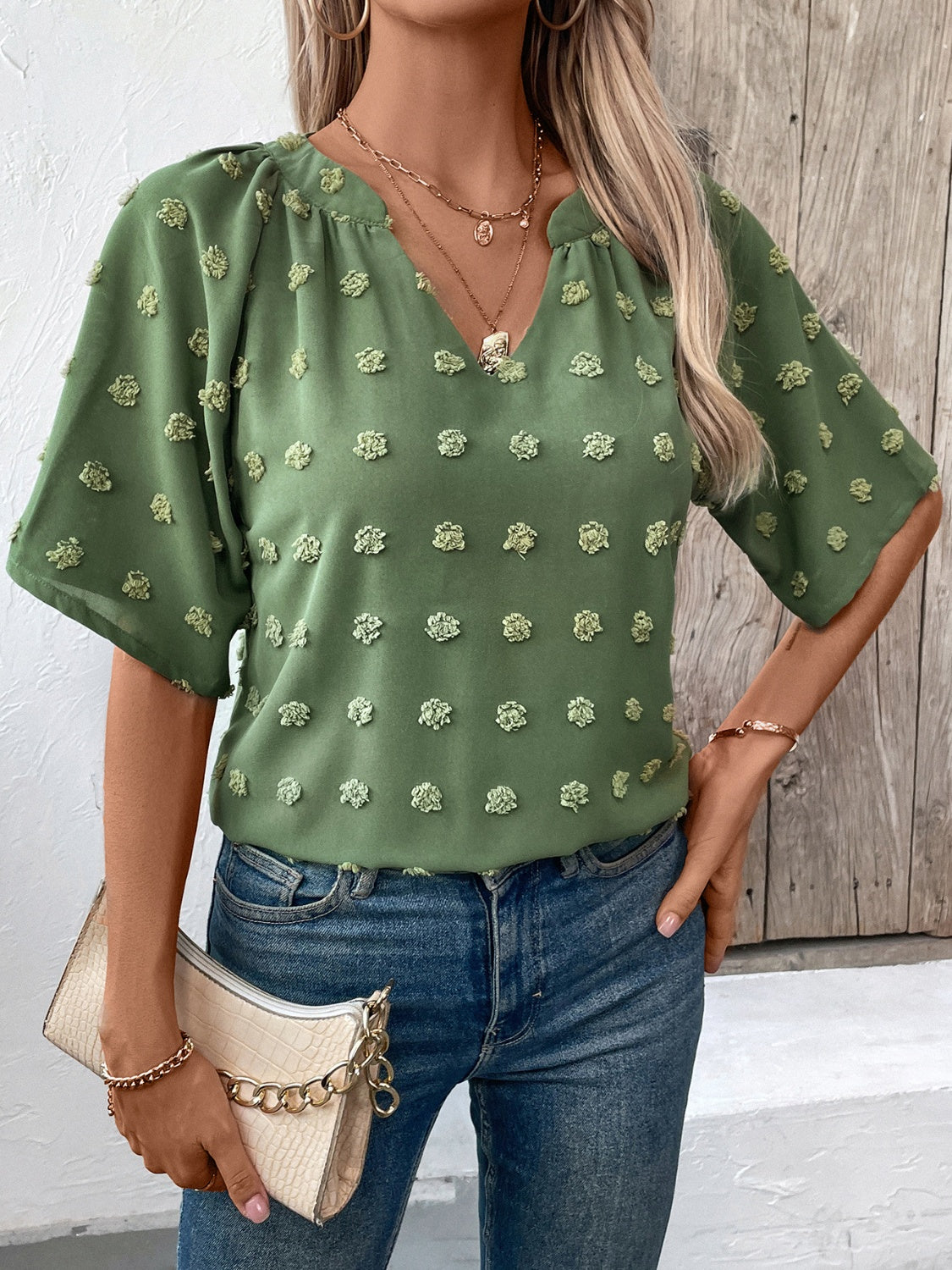 Moss green Swiss dot blouse with V-neck and short sleeves.