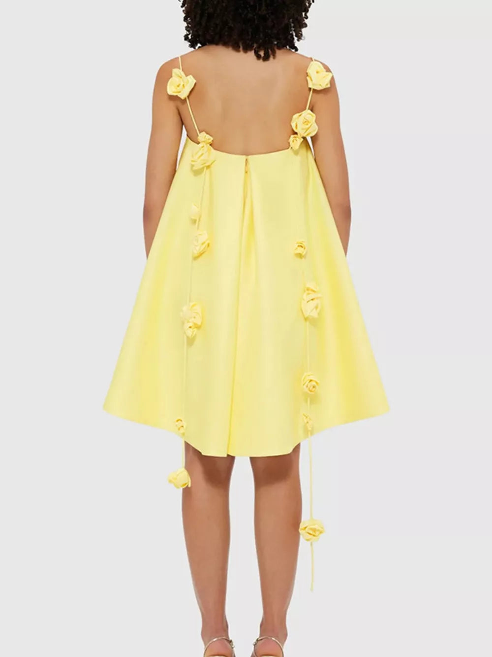 Yellow A-line mini dress with floral applique details on straps and hem.