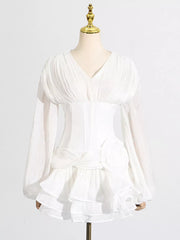 White ruffle mini dress with balloon sleeves and a ruched bodice.