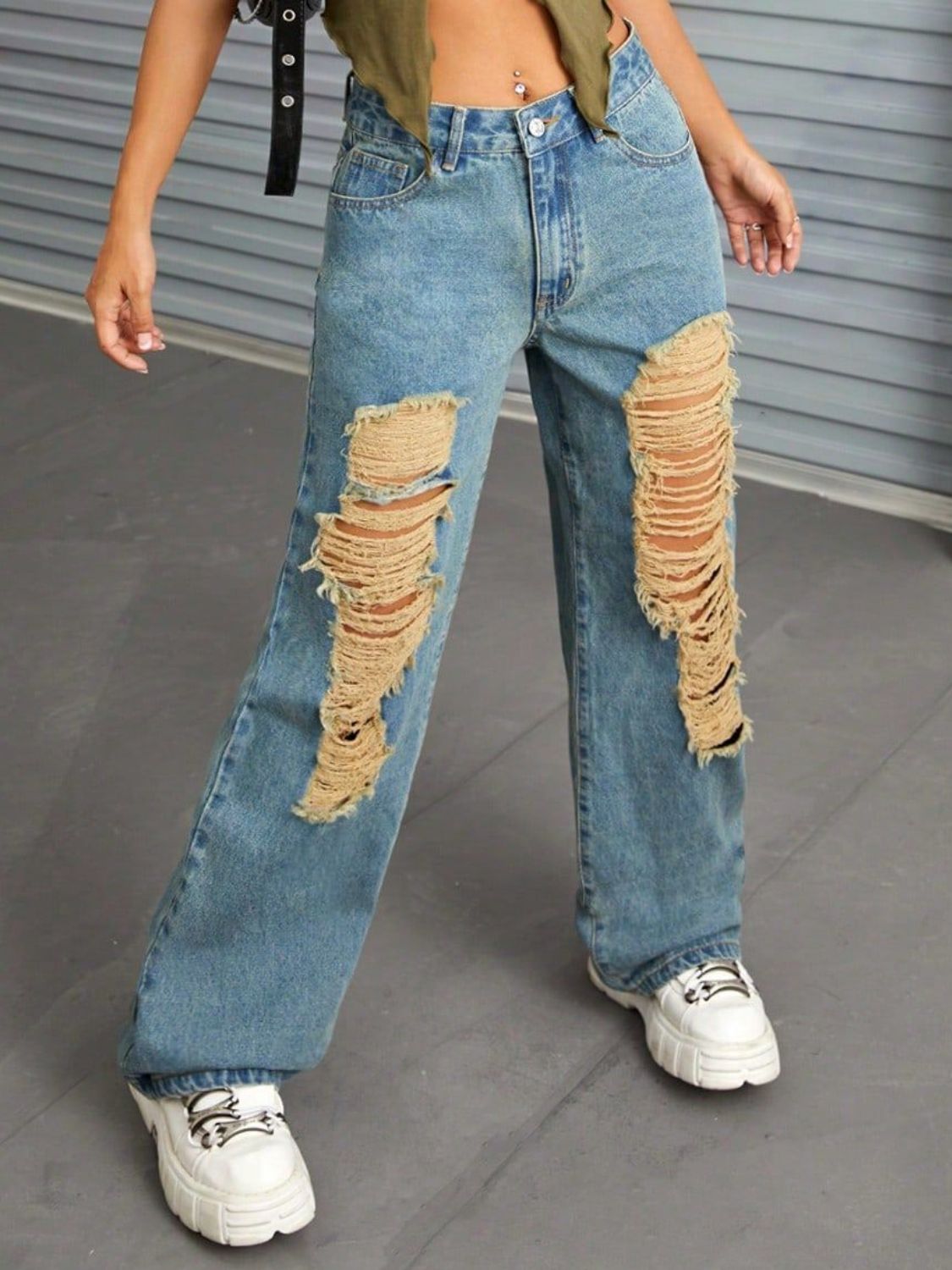 Medium wash denim jeans with distressed rips and raw edge detail.