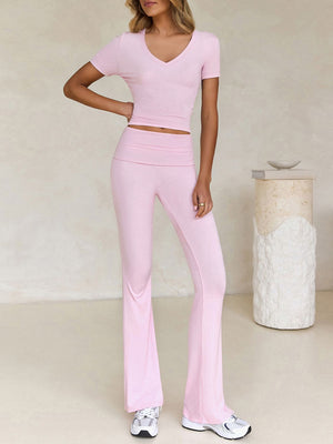 Blush pink ribbed flare leg lounge set with v-neck crop top and high-waisted pants.