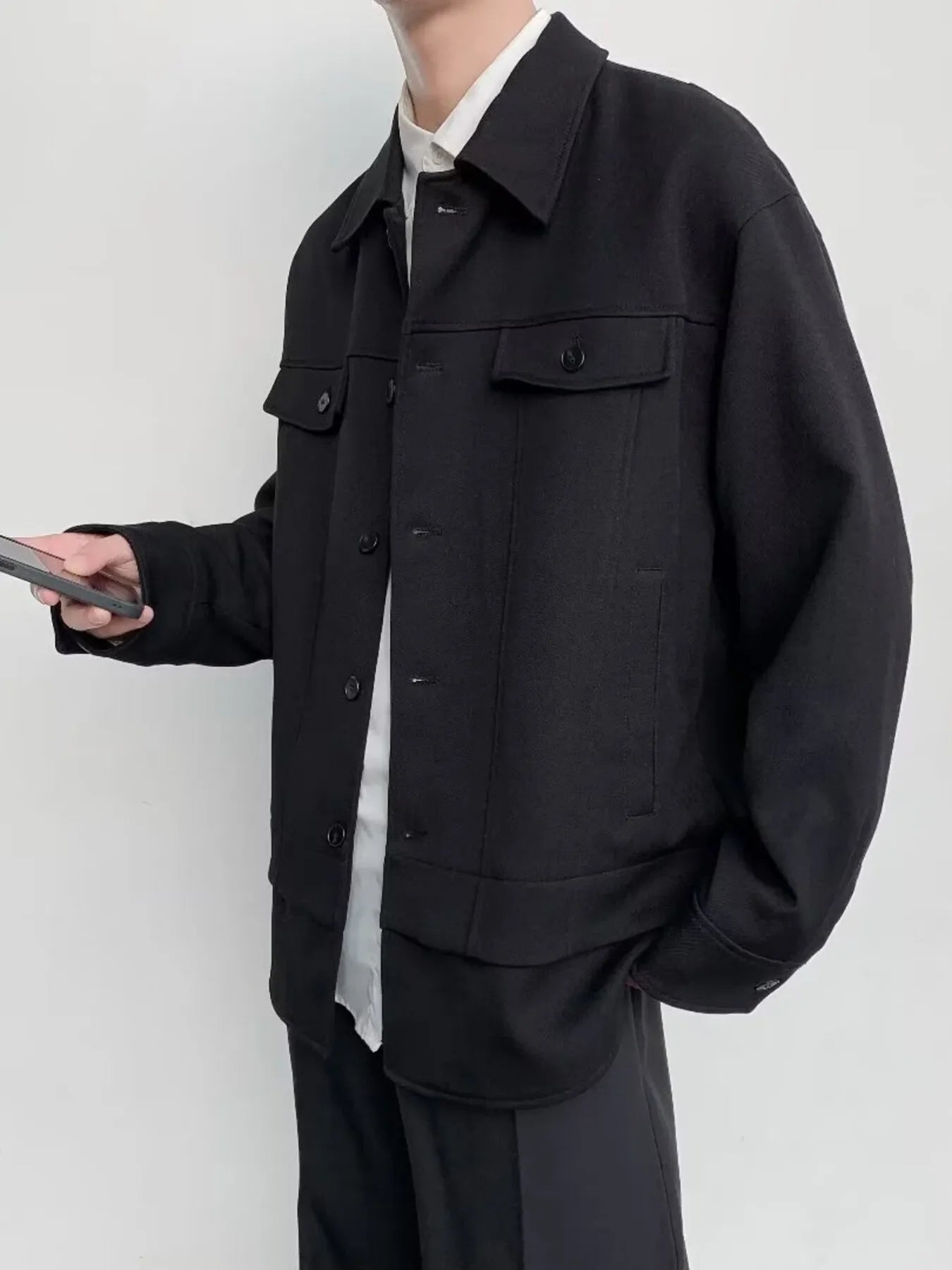 Black oversized button-down jacket with chest pockets and button closure.