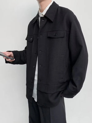 Black oversized button-down jacket with chest pockets and button closure.