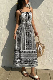 Black and white geometric print cami dress with tie-front bodice and maxi skirt.