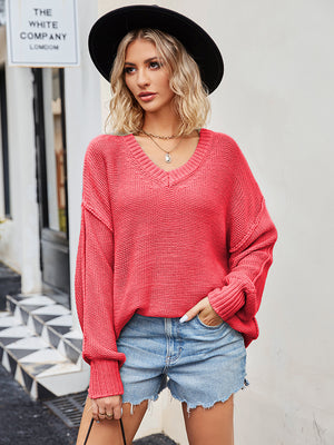 Oversized slouch knit V-neck sweater in coral with ribbed cuffs and hem.