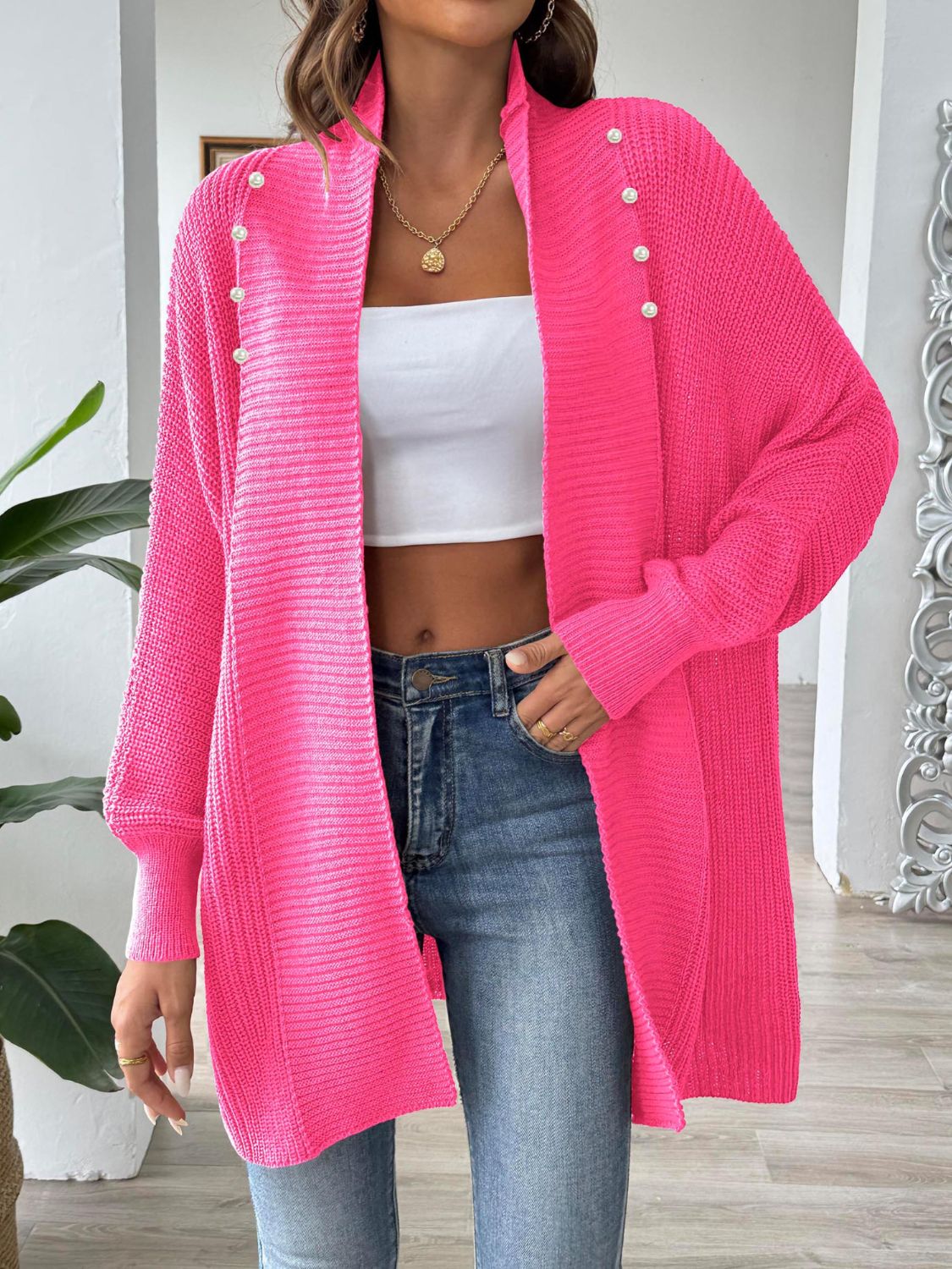 Pearl button ribbed knit cardigan in bright pink with a relaxed fit and open front.