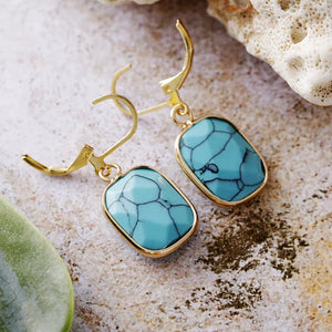 Turquoise stone and gold drop earrings with lever back closure.