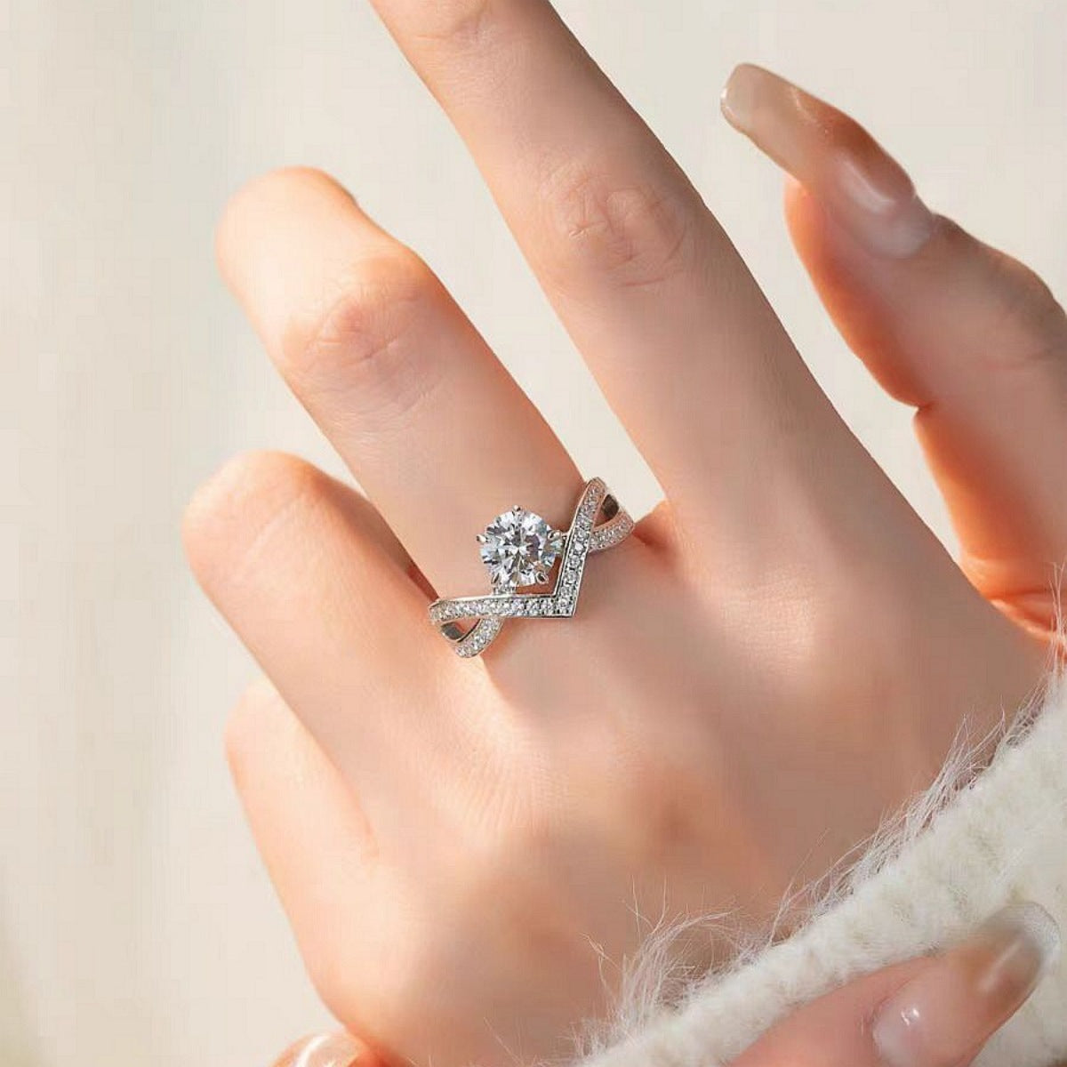 Sterling silver crossover ring with moissanite center stone and pavé band.