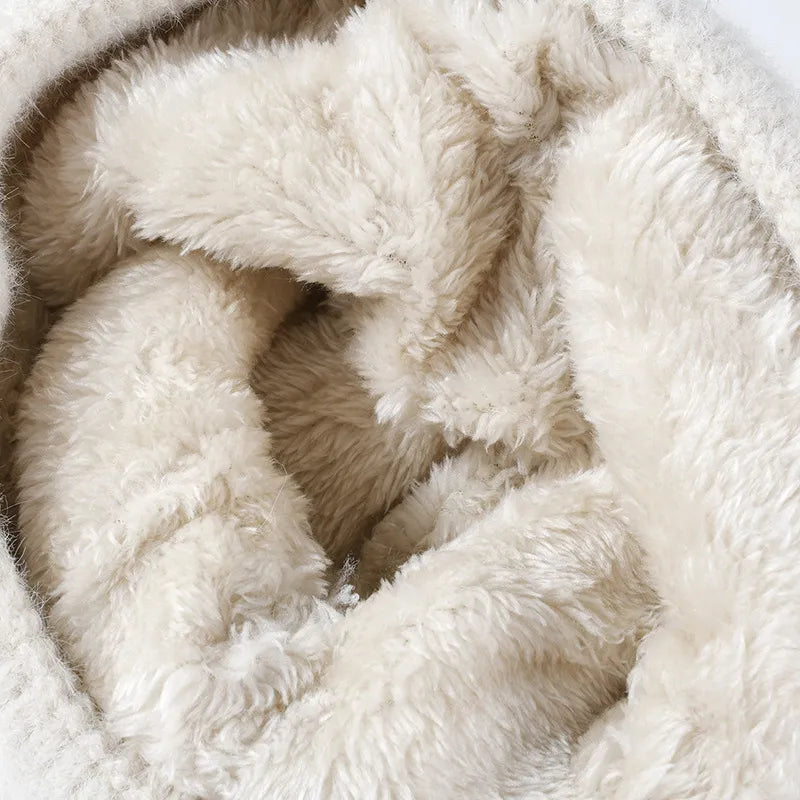 Beige textured knit beanie with fluffy sherpa lining and pom-pom bow detail.