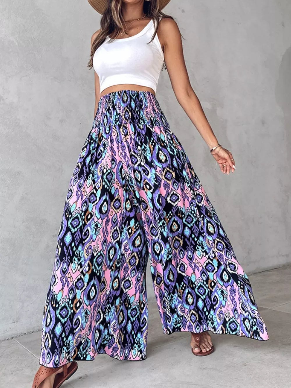 Bohemian print wide leg pants with smocked waist in purple, pink, and blue.